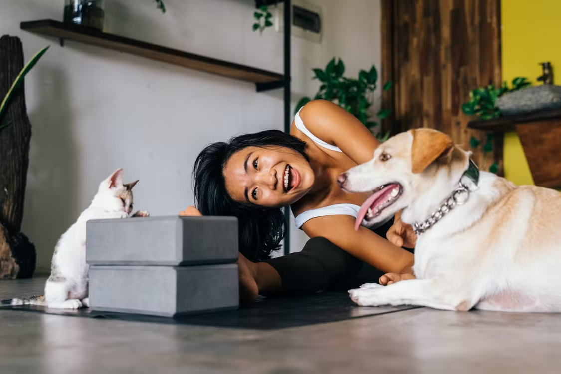 Ngườі phụ nữ vui vẻ bên cún cưng và mèo